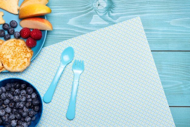 Top view of blueberries with cutlery and fruits