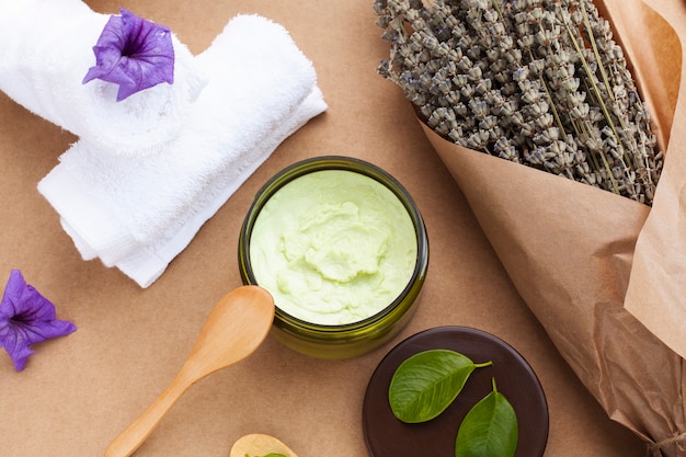 Top view of body butter and lavender on plain background