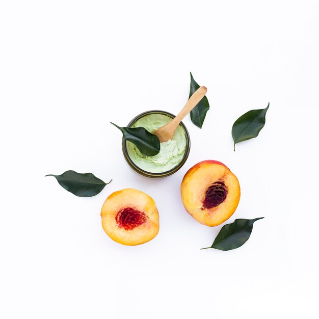 Top view of body butter and nectarines on white background