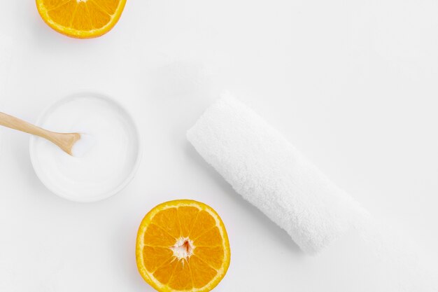 Top view of body butter and orange on white background