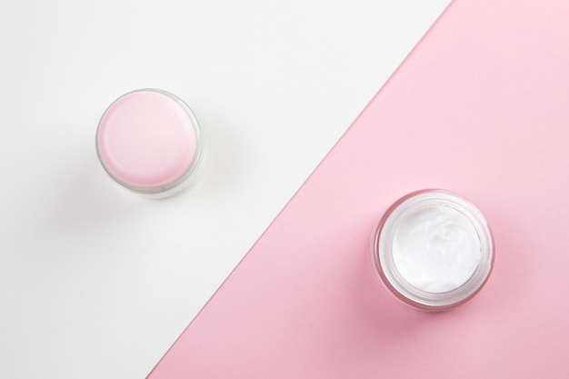 Top view of body cream on pink and white background