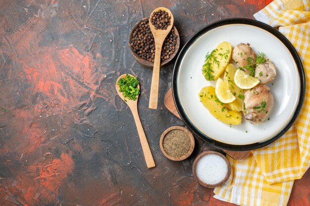 Top view boiled chicken with cooked potatoes greens and lemon on a dark background sauce cuisine dish color food dinner calorie meat