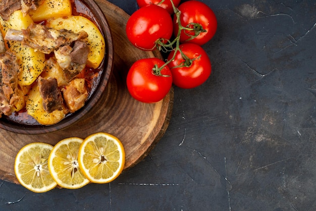 Вид сверху вареное мясо с вареным картофелем и лимоном на темном фоне блюдо соус кухня горячий ужин кухня приготовление мяса