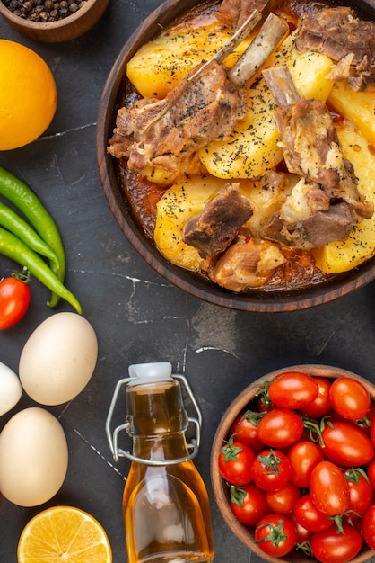 Вид сверху вареное мясо с картофелем и свежими овощами на темном фоне блюдо соус кухня горячий ужин кухня приготовление мяса