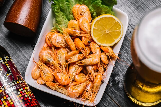 Top view boiled river shrimps with lemon and a glass of beer