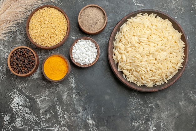 茹でた白米と未調理の白米とさまざまなスパイスの上面図