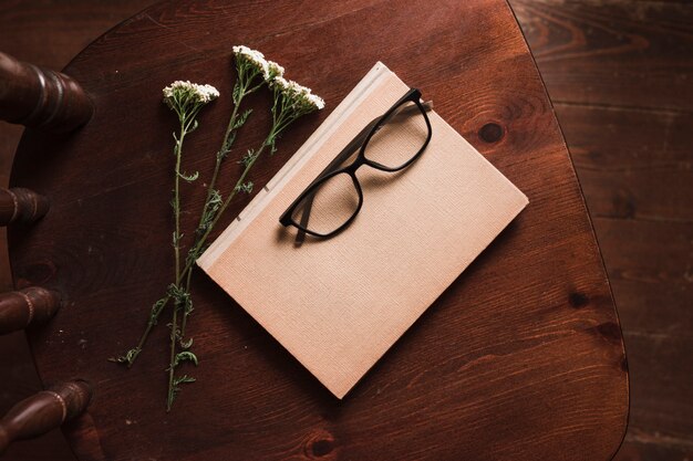 Top view of book, flowers and glasses