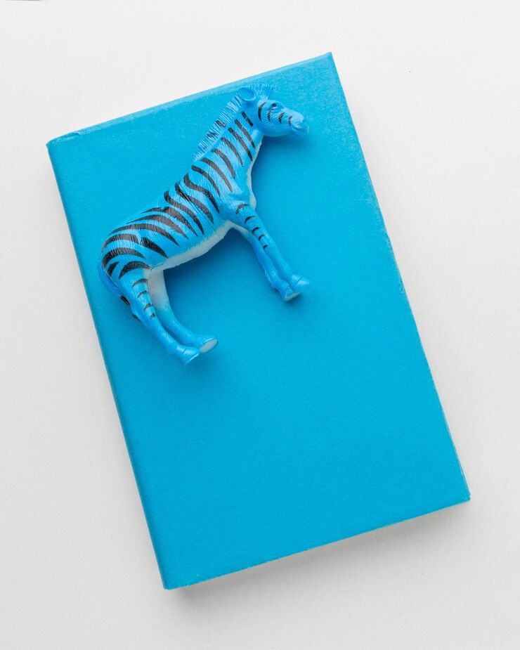 Бесплатный Фотография вид сверху книги с фигуркой зебры на день животных