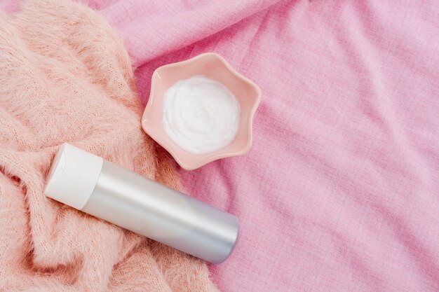 Top view of bottle and body butter on pink background