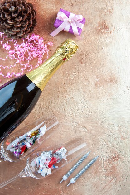 Top view bottle of champagne with little presents on light gift xmas photo color alcohol