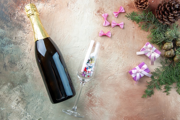 Top view bottle of champagne with little presents on a light gift xmas photo new year color alcohol