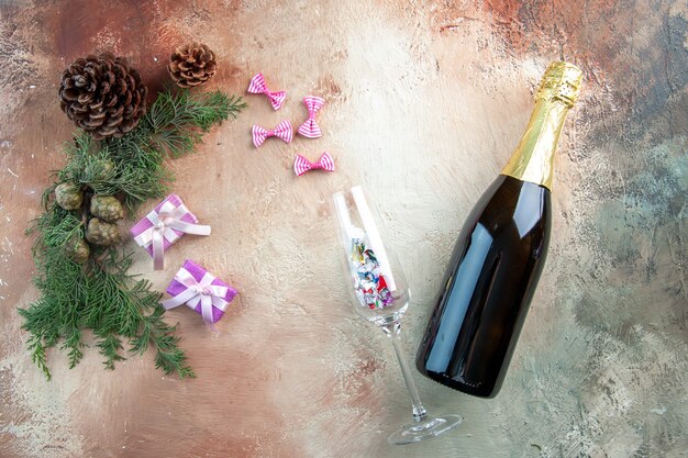 光のギフト クリスマス写真新年色アルコールに小さなプレゼントとシャンパンのトップ ビュー ボトル