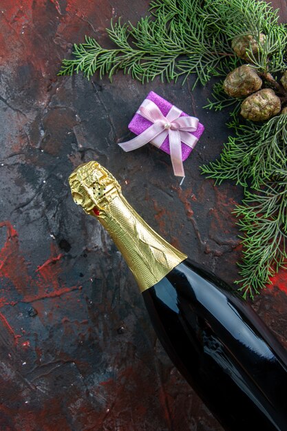 Top view bottle of champagne with present on dark color drink alcohol photo new year party