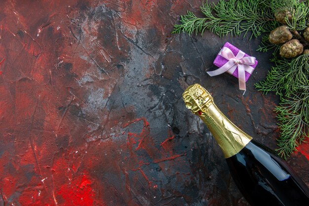 Top view bottle of champagne with presents on dark color drink alcohol photo new year party free space