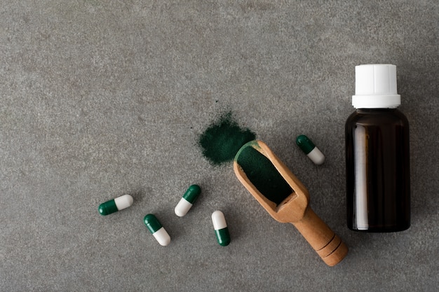 Top view bottle of oil with pills on the table