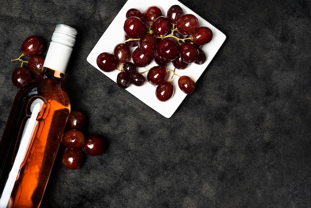 Foto gratuita vista dall'alto bottiglia di vino con uva