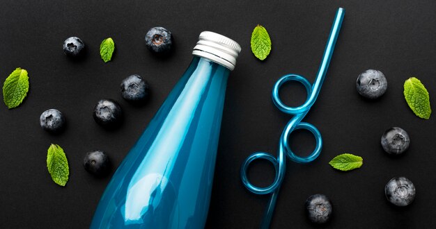 Top view of bottle with soft drink and blueberries