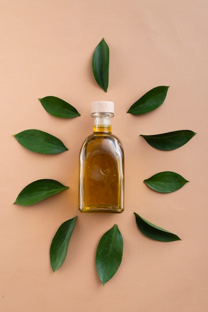 Free photo top view bottles filled with oil surrounded by leaves