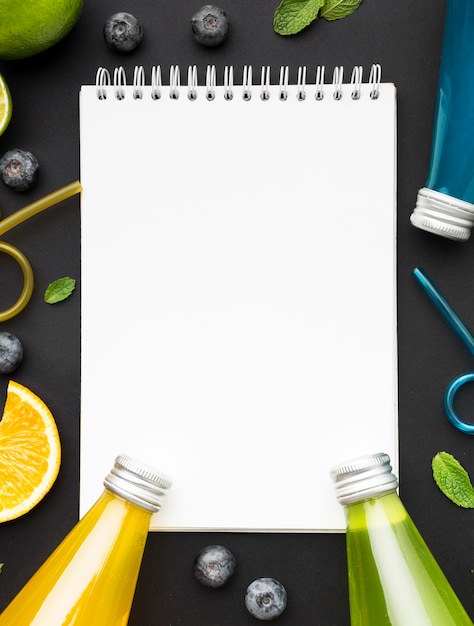 Top view of bottles with soft drinks and notebook