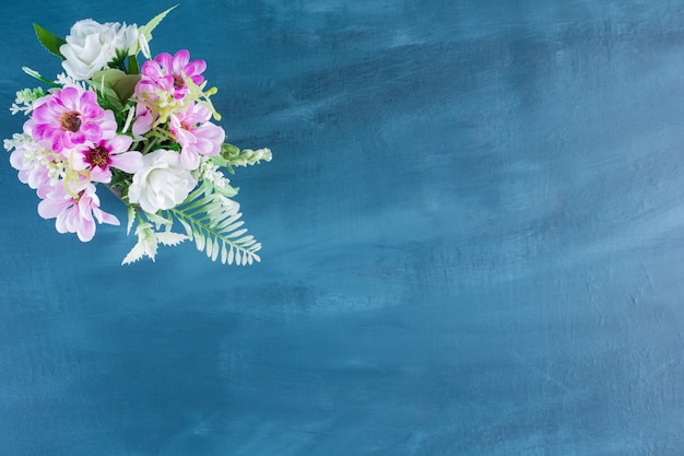 Free photo top view of bouquet of colorful flowers on blue background.