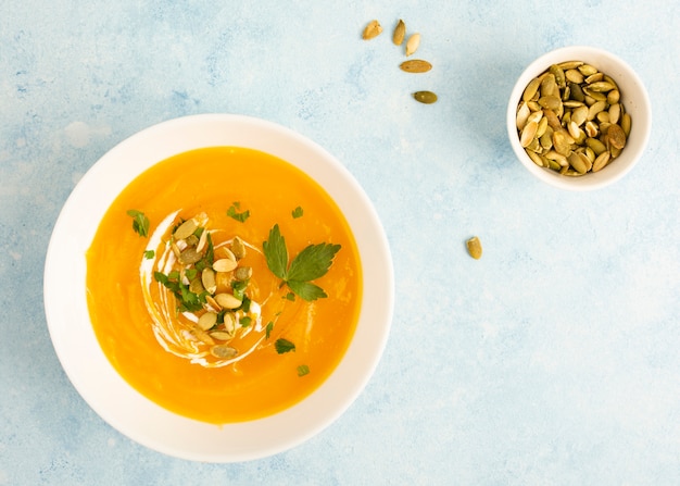 Top view bowl of cream soup beside seeds