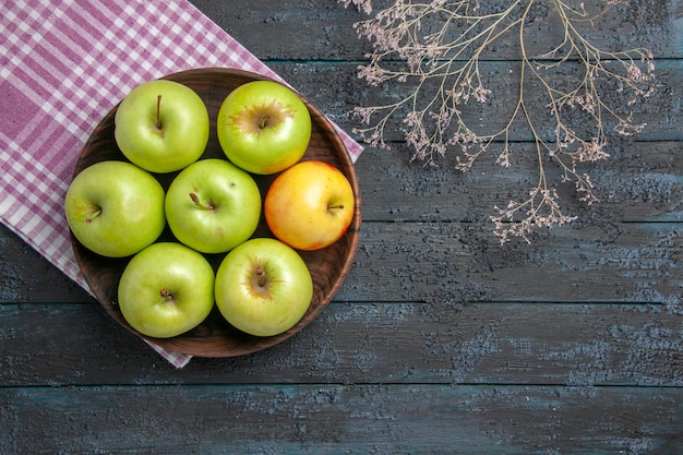 無料写真 リンゴの上面図ボウル枝の横にある市松模様のテーブルクロスに7つの緑黄色のリンゴのボウル