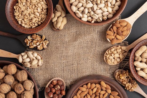 Free photo top view of bowl and spoon on burlap with assortment of nuts