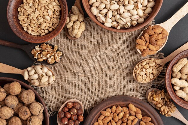 Top view of bowl and spoon on burlap with assortment of nuts