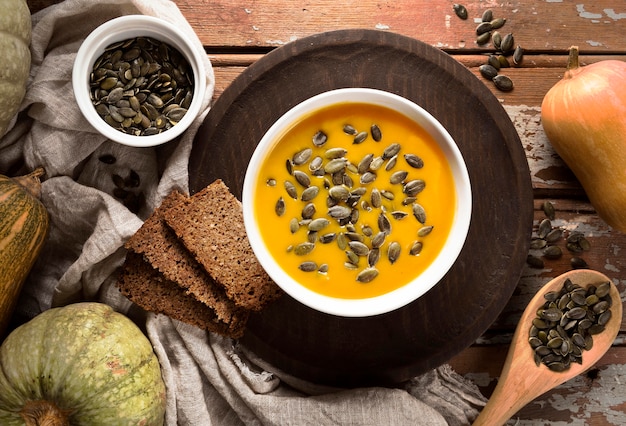 Top view of bowl with autumn squash soup and seeds