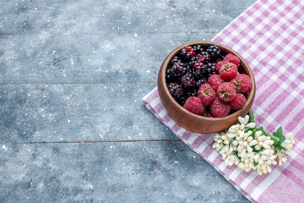 Free photo top view of bowl with berries fresh and ripe fruits on grey desk, berry fruit fresh ripe mellow forest