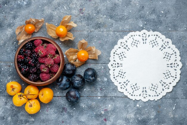 top view of bowl with berries fresh ripe fruits on grey wooden, berry fruit fresh mellow forest