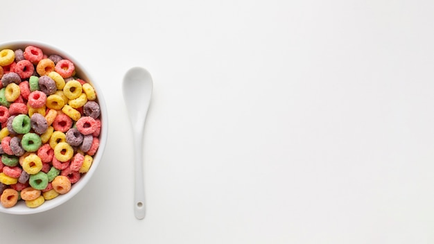 Foto gratuita ciotola vista dall'alto con cucchiaio di cereali e plastica