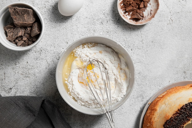 Top view bowl with eggs and flour on the table