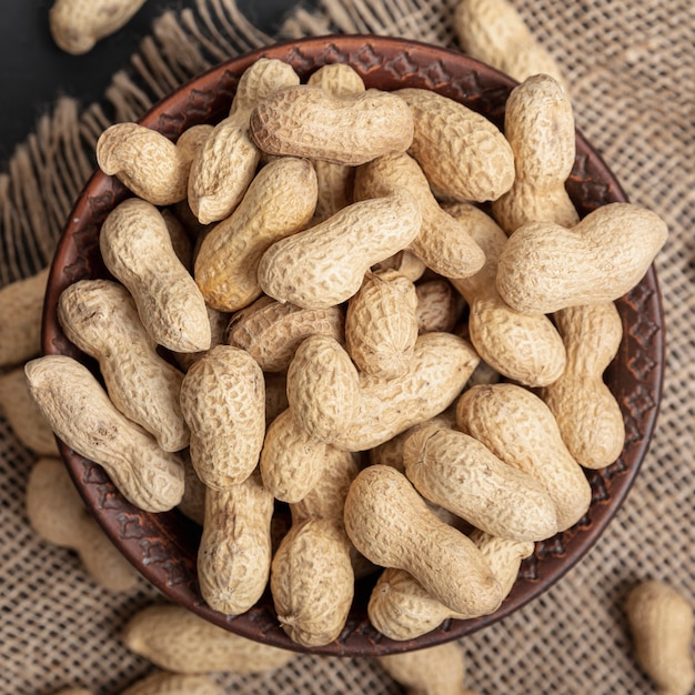 Top view of of bowl with peanuts on burlap