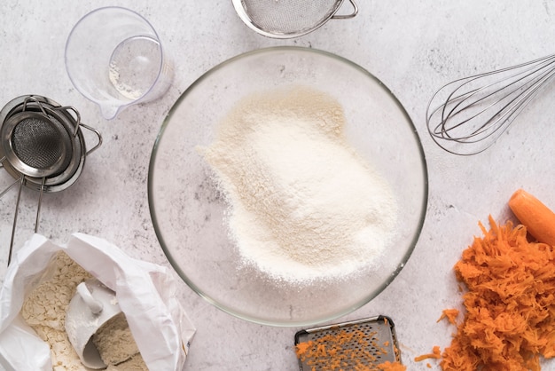 Top view bowl with sugar surrounded by carrots