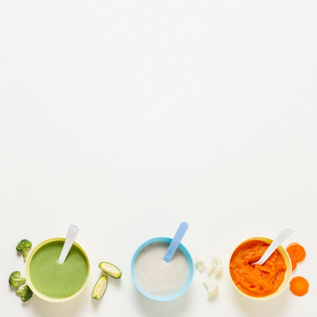 Free photo top view bowls frame with baby food