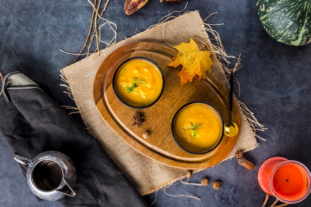 Top view of bowls of squash soup on wooden board