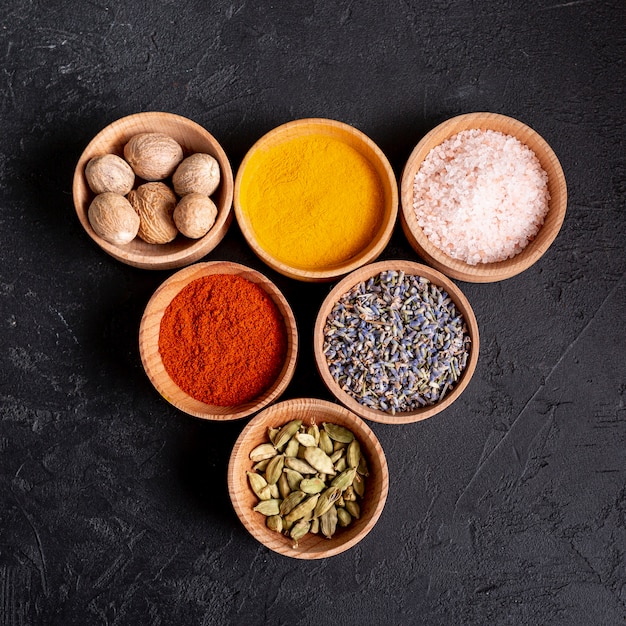 Top view of bowls with assortment of spices and salt