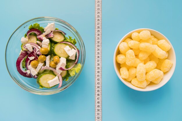 Top view bowls with salad and puffs