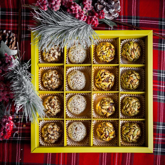 Top view box of sweet baked with rowan and spruce leaves in table