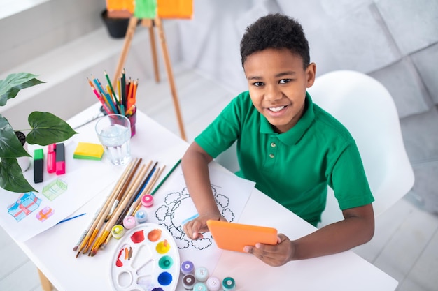 Top view of boy with tablet looking at camera