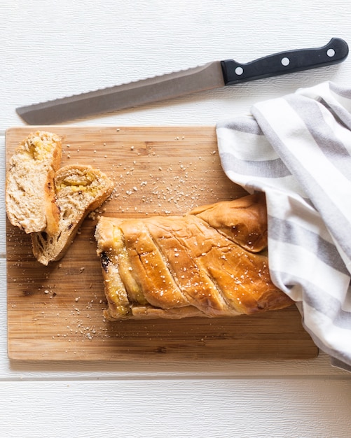 Top view of bread and knife on plain background