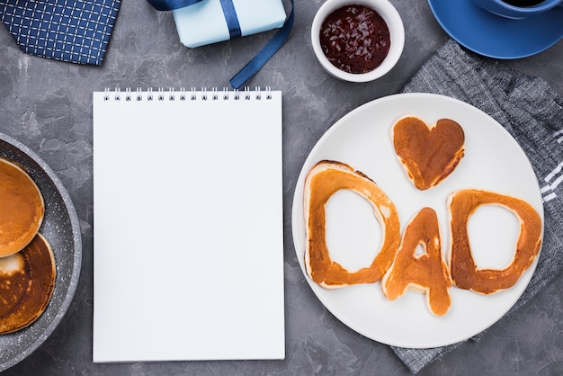 Top view bread letters for father's day and notepad