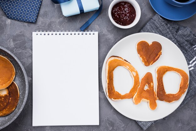 Top view bread letters for father's day and notepad