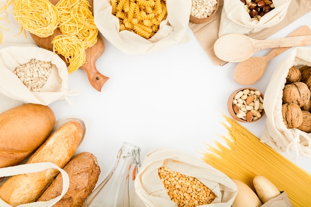 Top view of bread in reusable bag with bulk pasta and assortment of nuts