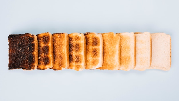 토스트의 다양한 단계에서 빵 조각의 상위 뷰 흰색 배경에 행으로 정렬