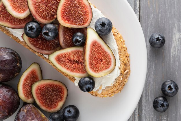 Top view bread with cream cheese , figs and blueberries