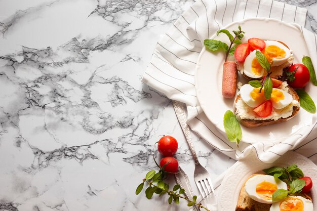 Top view bread with hard boiled eggs tomatoes and hotdog