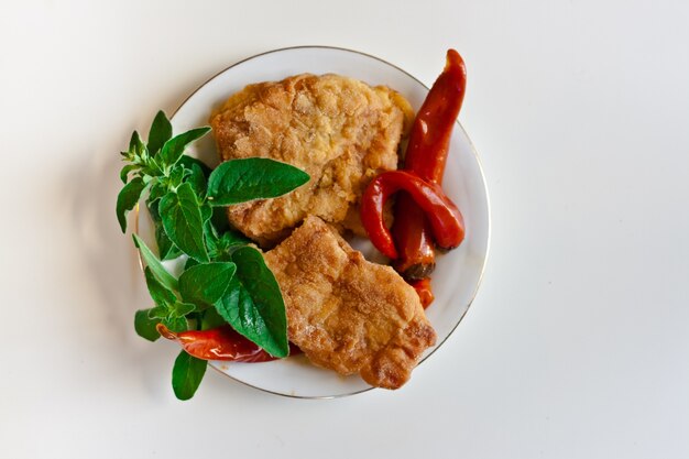 Top view of breaded chicken with chili peppers