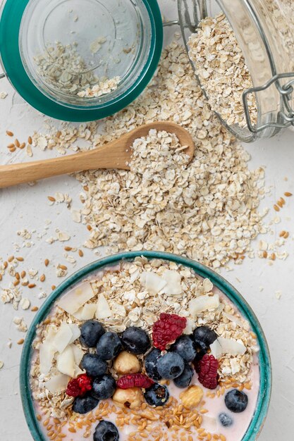 Top view of breakfast cereals in bowl with fruits and jar